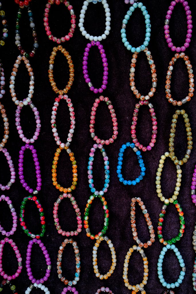 A vibrant collection of artisanal beaded bracelets displayed against a dark backdrop, showcasing eclectic style.