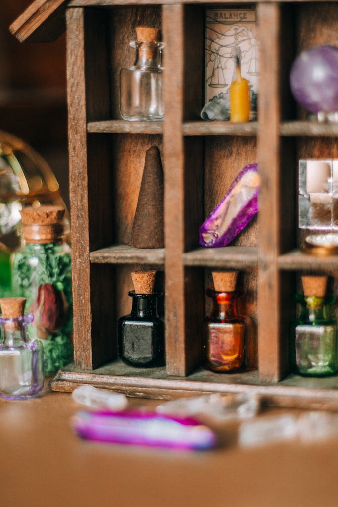 Close-up of a rustic shelf displaying colorful glass vials and corks in a cozy indoor setting.