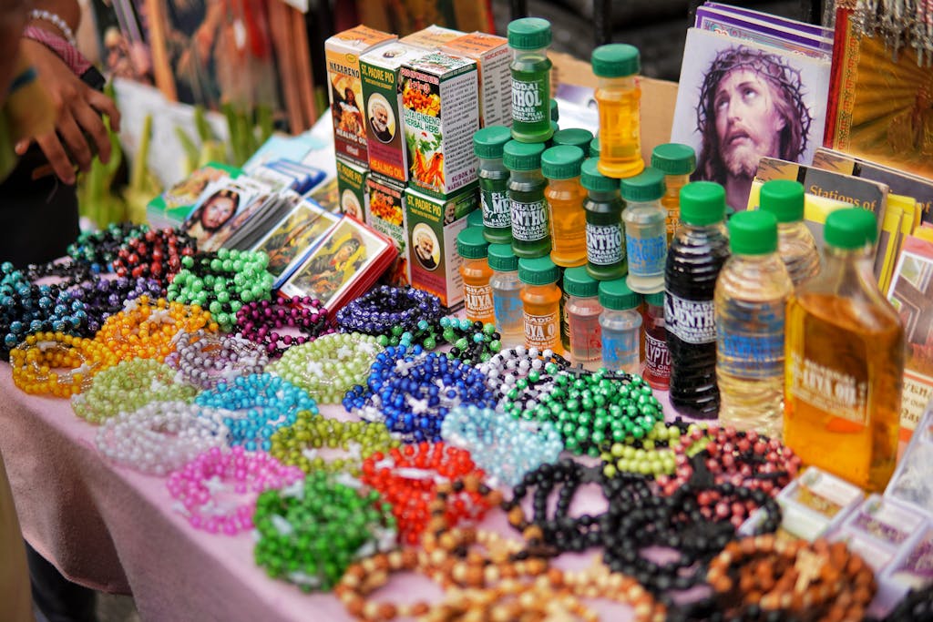 Vibrant display of religious items like rosaries and oils at a street market stall.